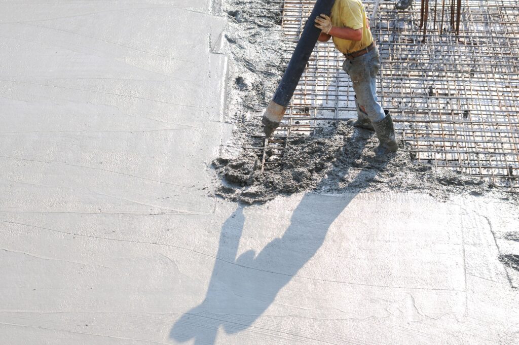 Worker placing concrete over rebar